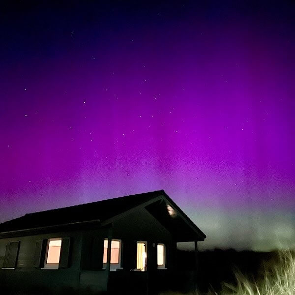 Ferienhaus im Bungalowdorf auf der Düne Helgoland bei Nacht vor Polarlichtern.