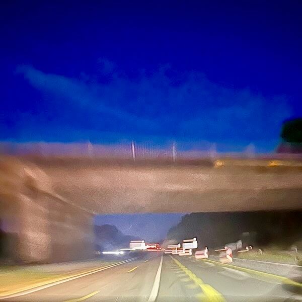 Brücke über eine Autobahn bei Nacht.